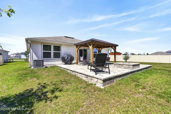 a view of a house with backyard and sitting area