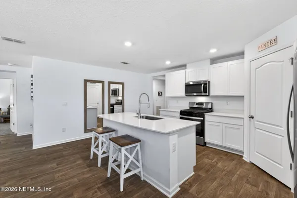 a kitchen with white cabinets and stainless steel appliances