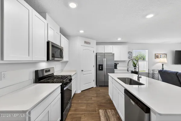 a kitchen with refrigerator a stove a sink and cabinets