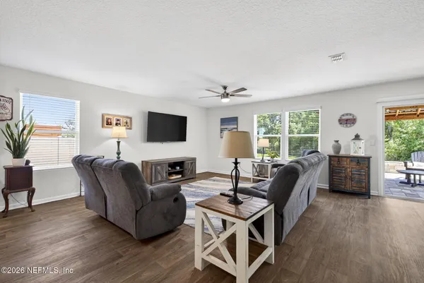 a living room with furniture a flat screen tv and a large window