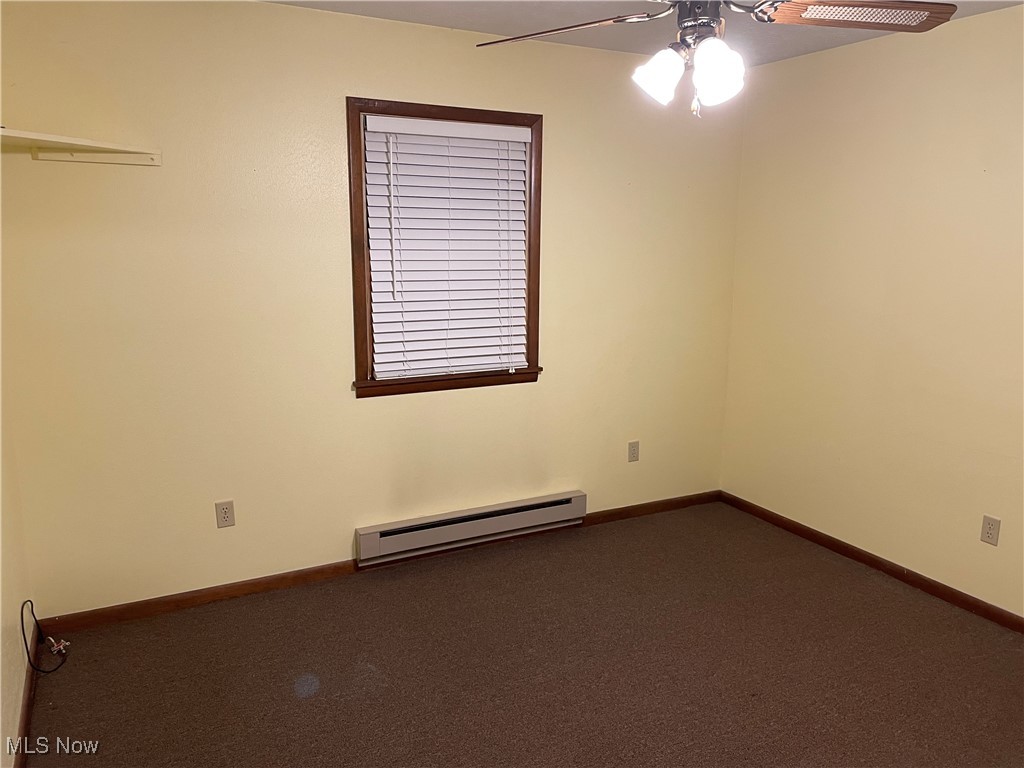 1381 Robb Road Conneaut, OH 44030 - Photo 25 of 50 Empty room featuring dark colored carpet, a baseboard radiator, and ceiling fan