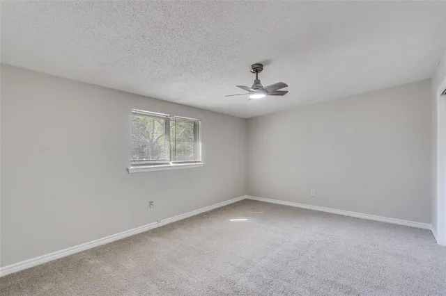a view of a big room with windows and chandelier fan