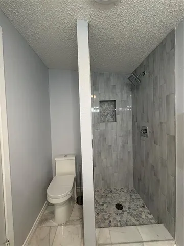 a bathroom with a toilet and a shower