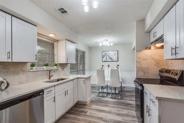 a kitchen with stainless steel appliances granite countertop a sink stove and cabinets