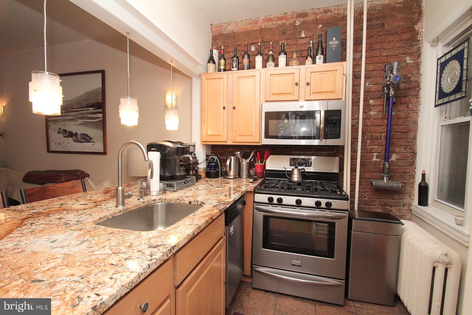 511 South 17th Street, Unit 1 Philadelphia, PA 19146 - Photo 2 of 15 a kitchen with granite countertop a stove a sink and a microwave