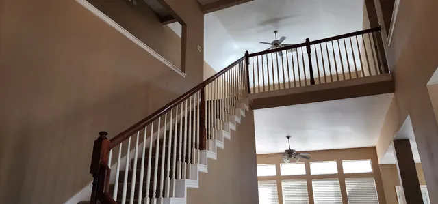 a view of staircase with railing and white walls