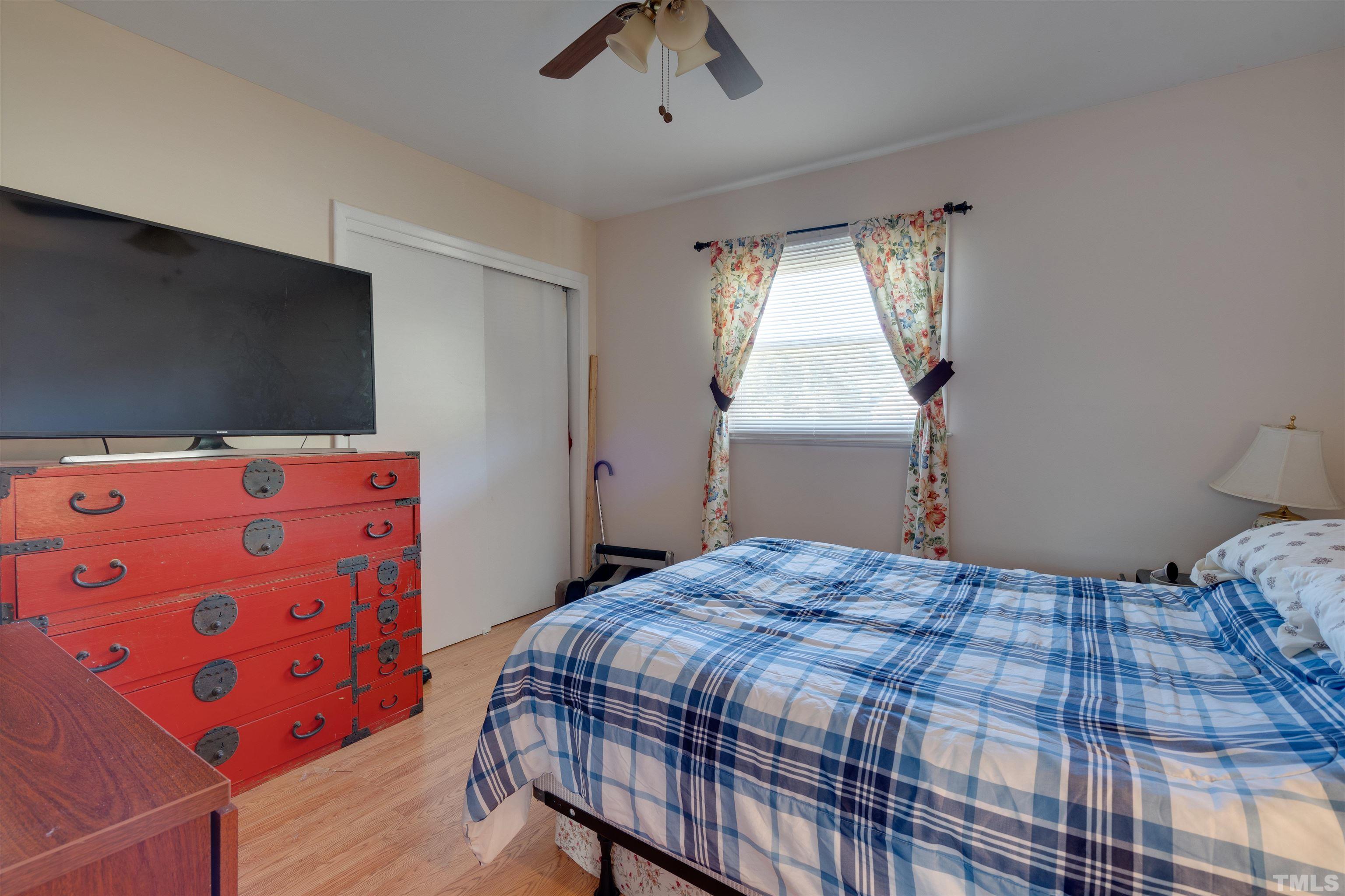 245 Pilot-Riley Road Zebulon, NC 27597 - Photo 20 of 22 a bedroom with a bed and a chandelier
