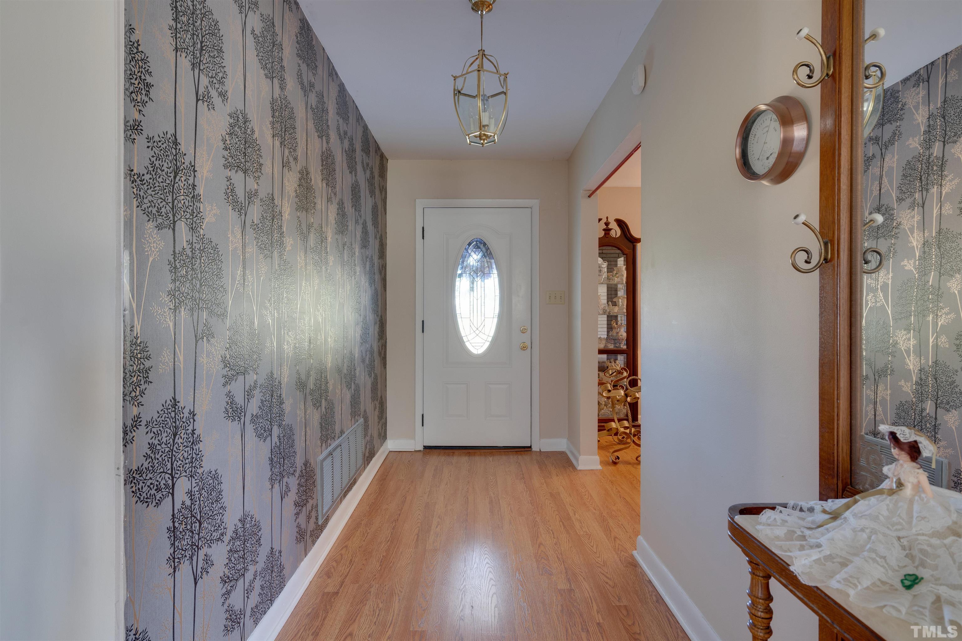 245 Pilot-Riley Road Zebulon, NC 27597 - Photo 7 of 22 a view of a hallway with wooden floor and a chandelier