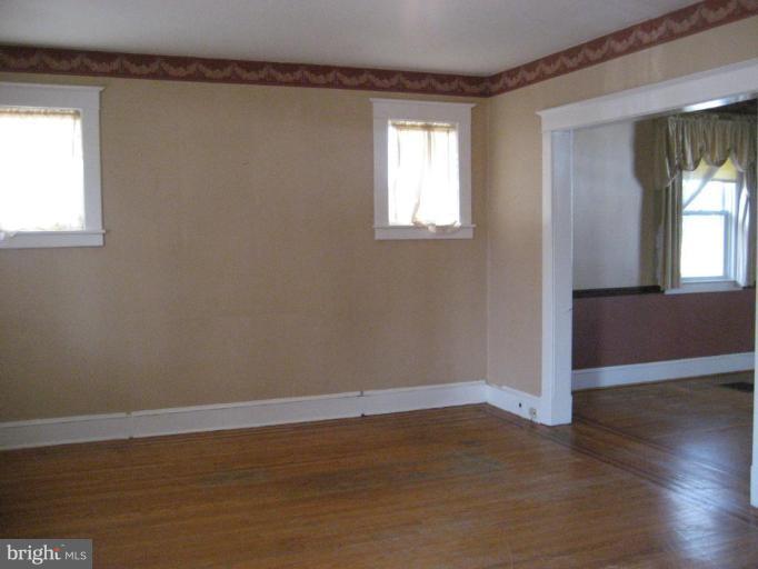 503 Westgate Road Baltimore, MD 21229 - Photo 20 of 24 an empty room with wooden floor and windows
