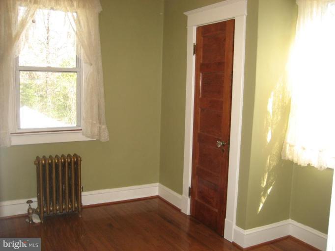 503 Westgate Road Baltimore, MD 21229 - Photo 5 of 24 an empty room with wooden floor and windows