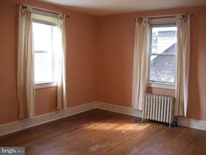 503 Westgate Road Baltimore, MD 21229 - Photo 10 of 24 an empty room with wooden floor and windows