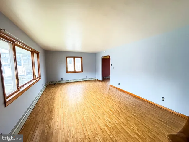 a view of empty room with window and wooden floor
