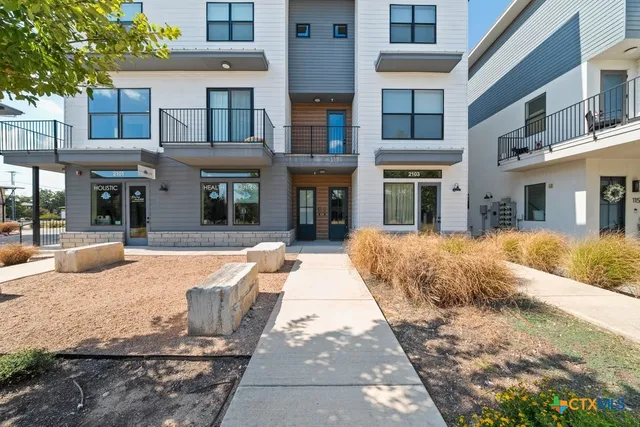 a front view of a building and car parked