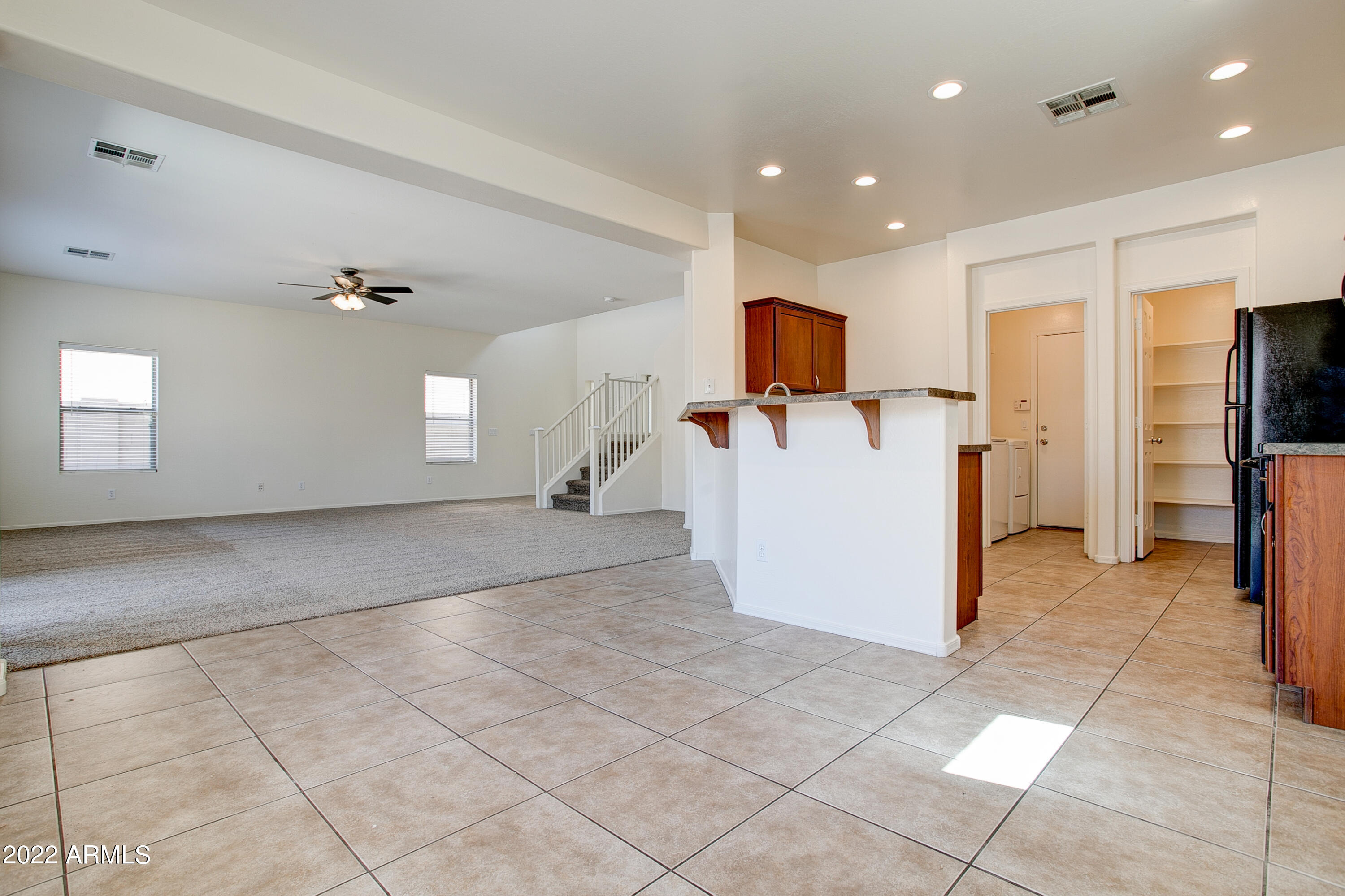 9928 West Chipman Road Tolleson, AZ 85353 - Photo 11 of 42 a view of a kitchen with a refrigerator and a stove top oven
