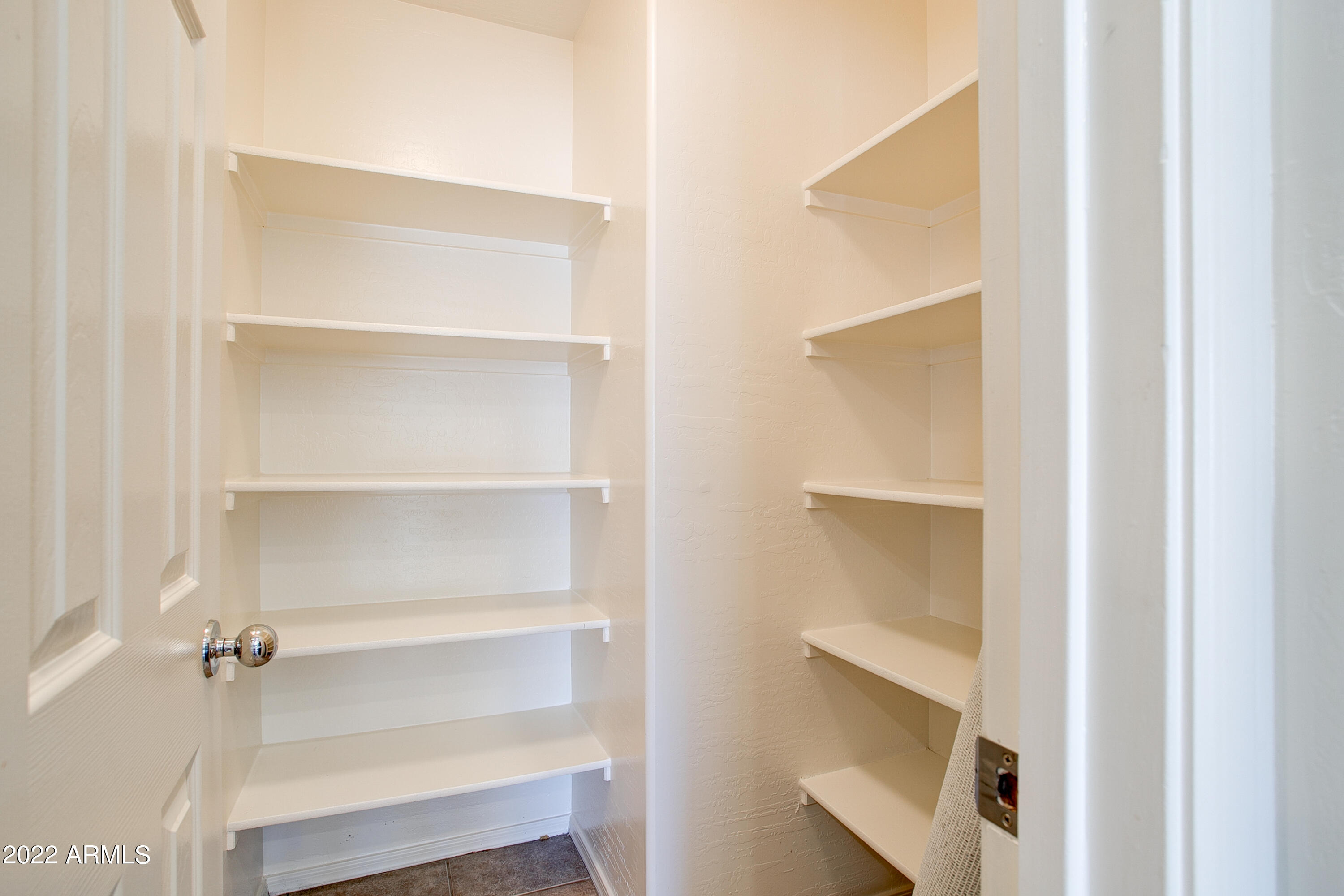 9928 West Chipman Road Tolleson, AZ 85353 - Photo 13 of 42 a view of walk in closet with empty racks