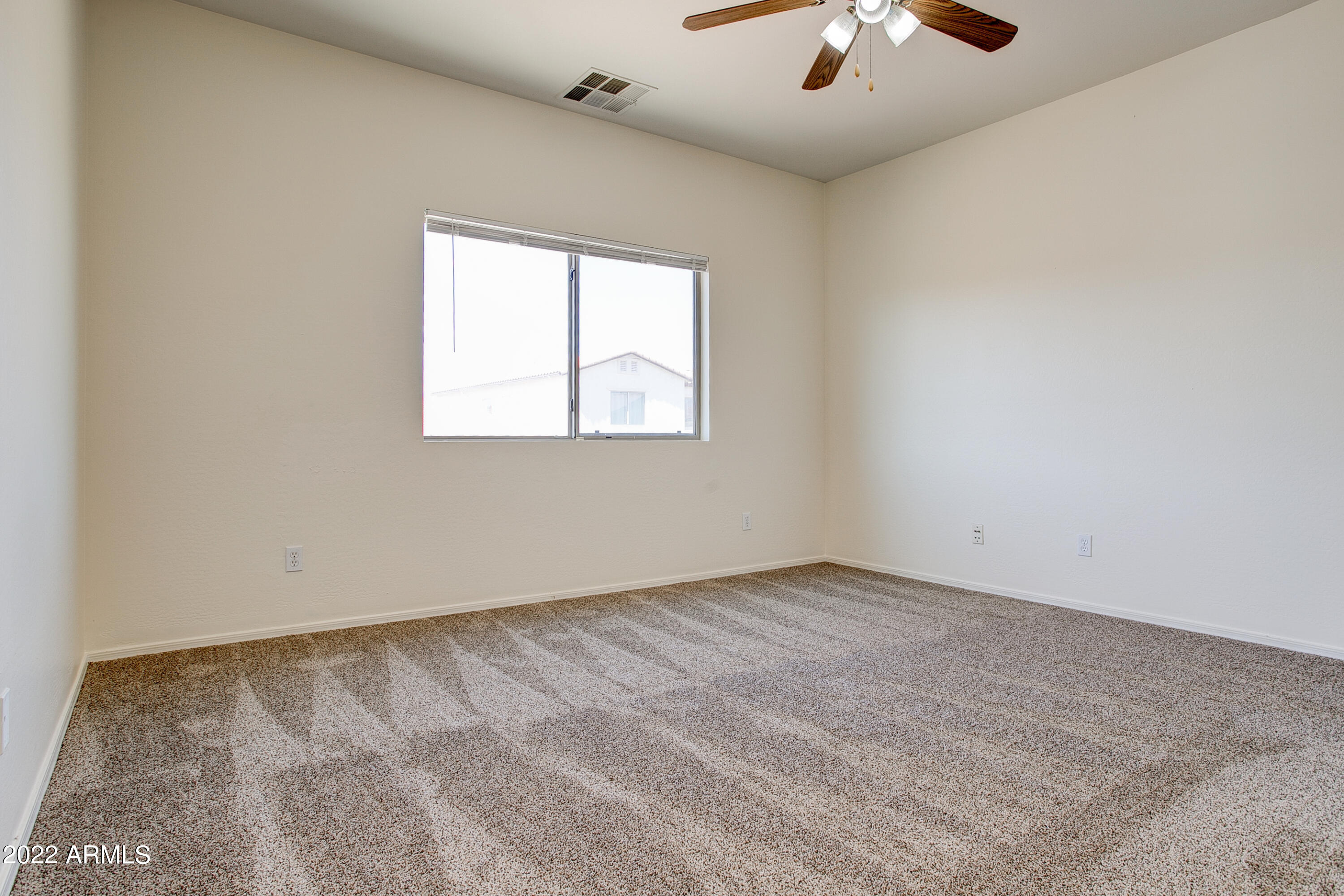 9928 West Chipman Road Tolleson, AZ 85353 - Photo 25 of 42 an empty room with windows and chandelier fan