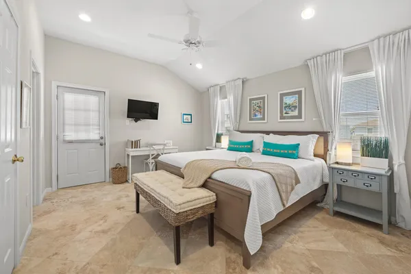 a spacious bedroom with a bed and a flat screen tv