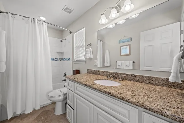 a bathroom with a granite countertop sink a large mirror and a shower