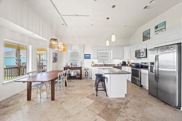 a kitchen with stainless steel appliances granite countertop a refrigerator and a stove top oven