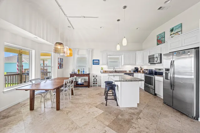 a kitchen with stainless steel appliances granite countertop a refrigerator and a stove top oven