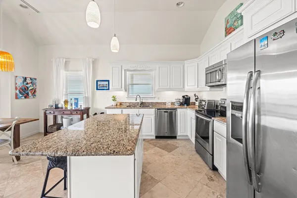 a kitchen with granite countertop a sink stove and cabinets