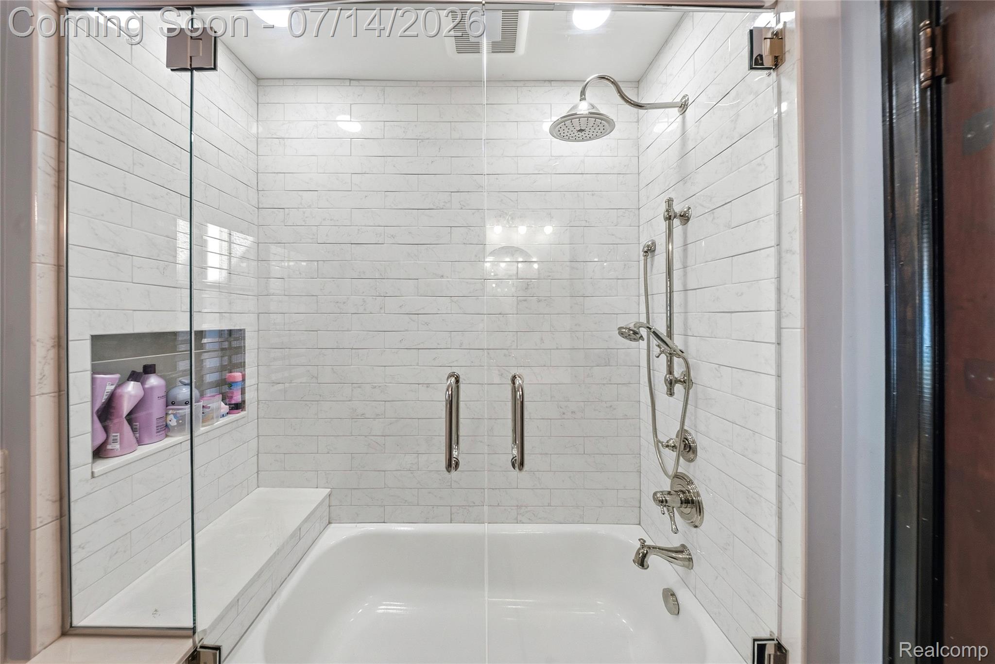 18460 Meridian Road Grosse Ile, MI 48138 - Photo 31 of 50 Glass-enclosed tub and shower combination featuring subway tile surround, rain shower head, handheld shower, built-in bench, and recessed shelving