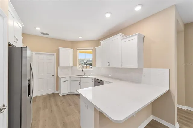 a kitchen with a refrigerator a sink and cabinets