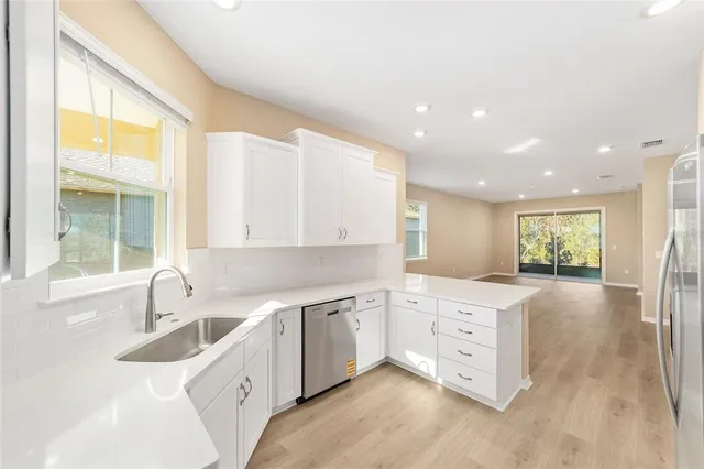 a kitchen with a sink window and cabinets