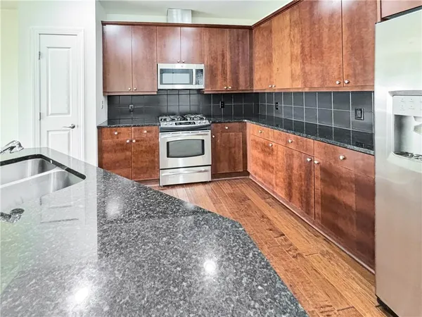 a kitchen with stainless steel appliances granite countertop a sink stove and cabinets