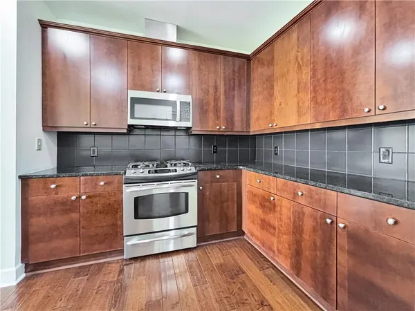 a kitchen with stainless steel appliances wooden cabinets and a stove top oven