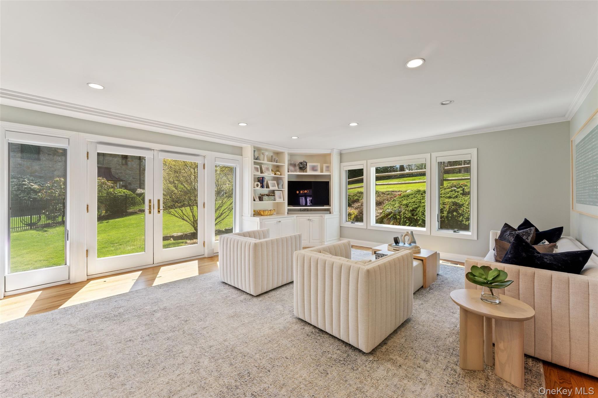 30 Corell Road Scarsdale, NY 10583 - Photo 3 of 32 Bright and inviting family room with lovely views of the well manicured property, built-ins, oversized windows, and French doors opening to the property.