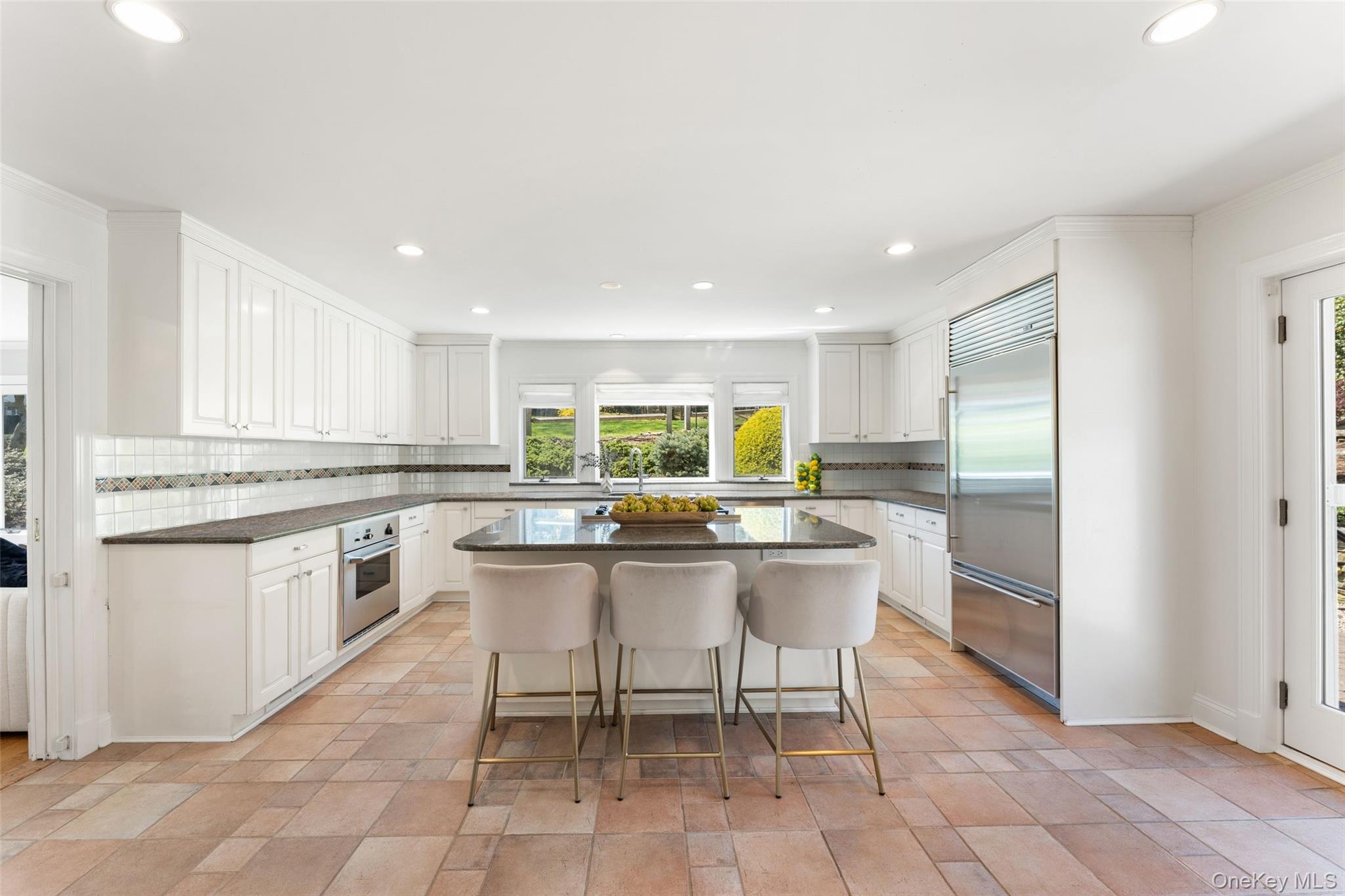30 Corell Road Scarsdale, NY 10583 - Photo 8 of 32 Sunny well-appointed eat-in kitchen with generous large island, dining space, large windows, and access to the patio.