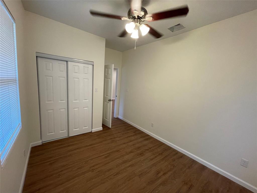 5424 Cottey Street Fort Worth, TX 76105 - Photo 5 of 8 an empty room with wooden floor fan and windows
