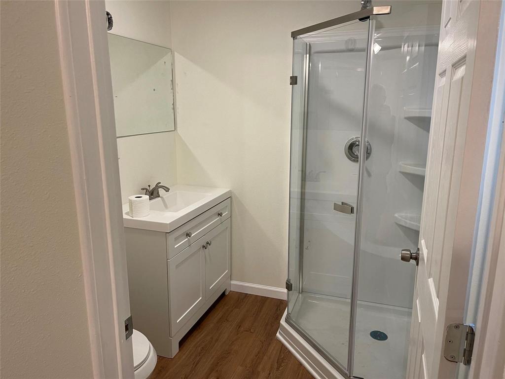 5424 Cottey Street Fort Worth, TX 76105 - Photo 7 of 8 a bathroom with a shower sink and mirror