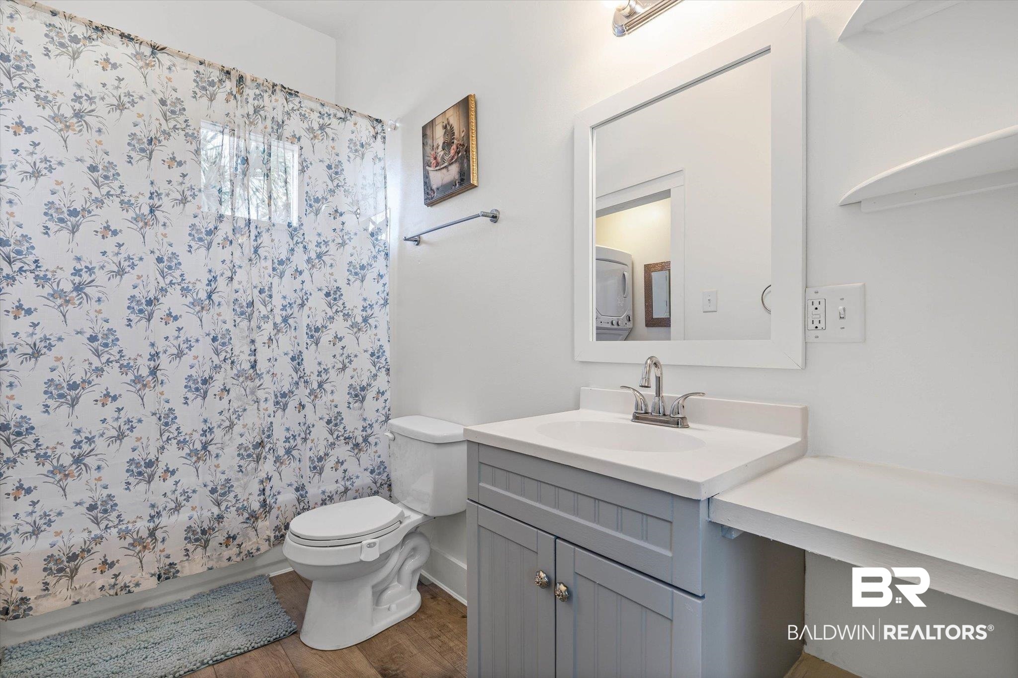 951 Montgomery Street Mobile, AL 36604 - Photo 16 of 22 Bathroom featuring a single vanity with a gray cabinet, white countertop, and a framed mirror