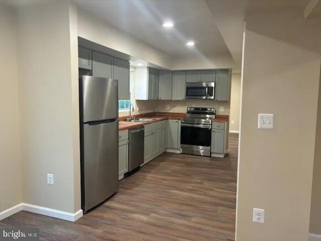 a view of a room with wooden floor and a kitchen