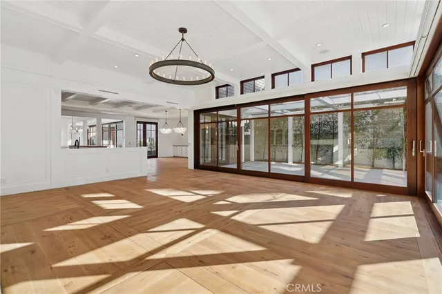 a view of a room with wooden floor and large windows