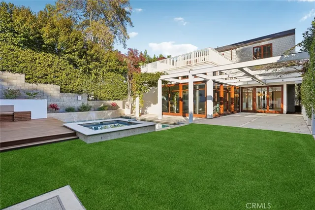 a view of an empty room with kitchen and a window