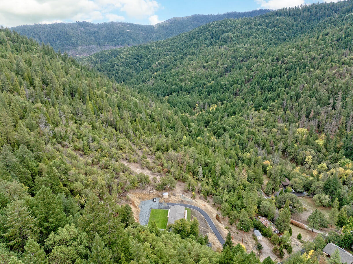 5572 Jumpoff Joe Creek Road Grants Pass, OR 97526 - Photo 30 of 38 a view of a lush green forest with a house