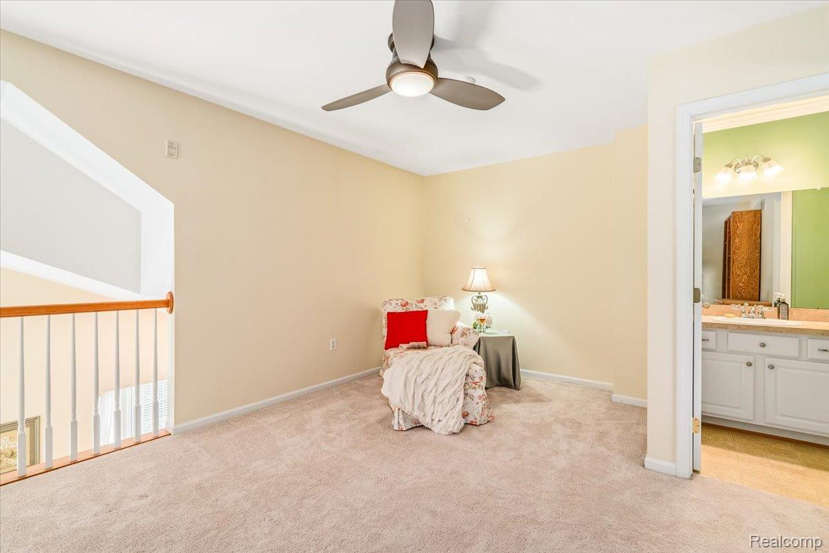 49105 Hawksburry Road Canton, MI 48188 - Photo 26 of 51 Carpeted open loft area featuring a ceiling fan, sloped ceiling, and wood-finish railing