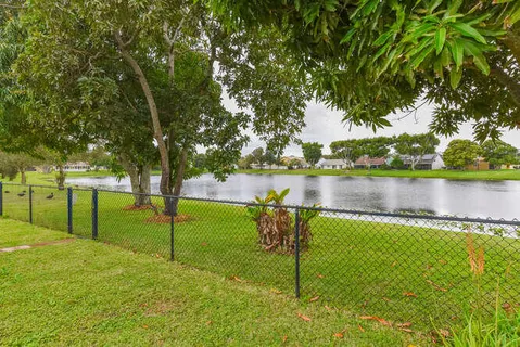 a view of a lake with a bench and trees