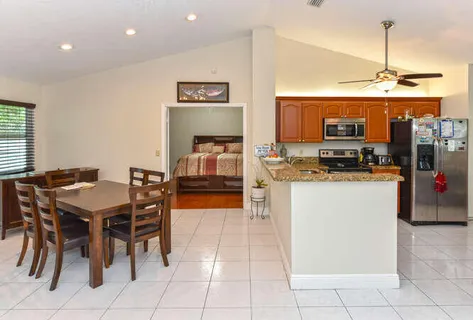 a kitchen with stainless steel appliances granite countertop a table and chairs in it