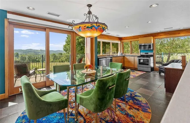 a living room with stainless steel appliances granite countertop furniture a rug and a window