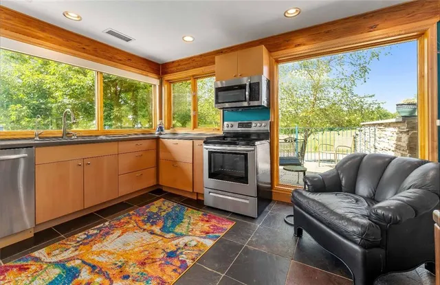 a bedroom with a bed a chair and a large window