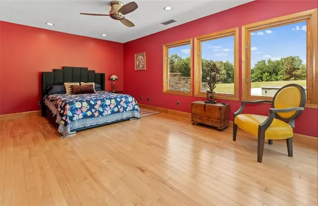 a bedroom with a bed and large windows