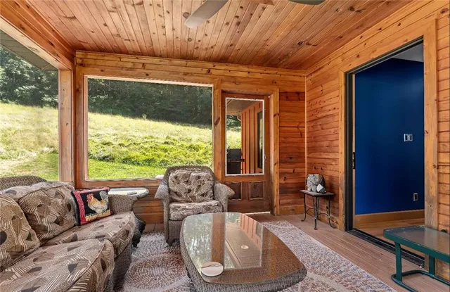 a living room with furniture and floor to ceiling windows