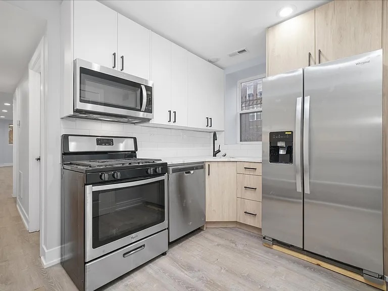 1916 North Ridgeway Avenue, Unit GDN Chicago, IL 60647 - Photo 5 of 9 a kitchen with white cabinets stainless steel appliances and a counter space