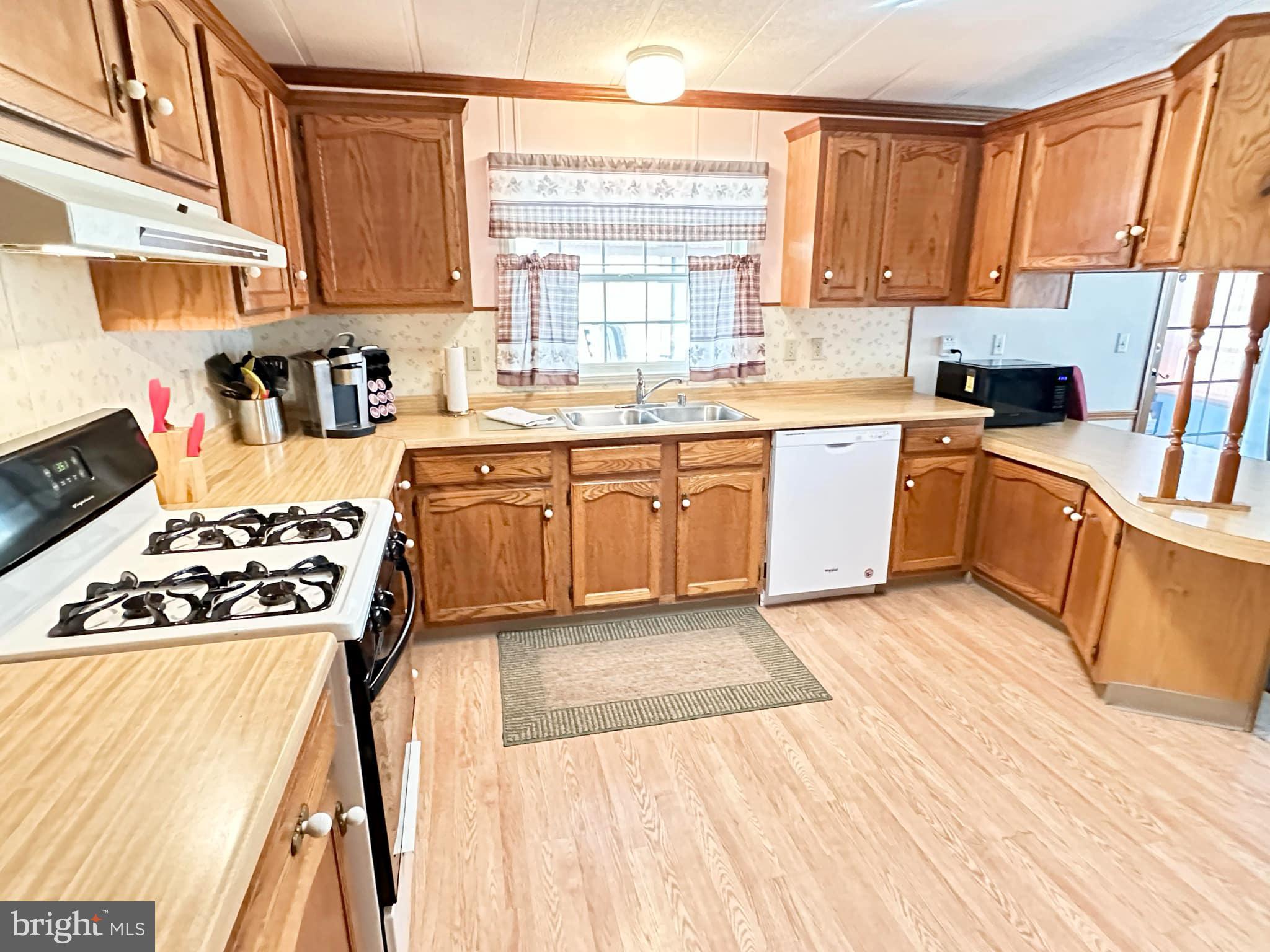 314 John Alden Drive Buena, NJ 08310 - Photo 17 of 23 a kitchen with stainless steel appliances granite countertop a stove a sink dishwasher and a microwave oven with white cabinets