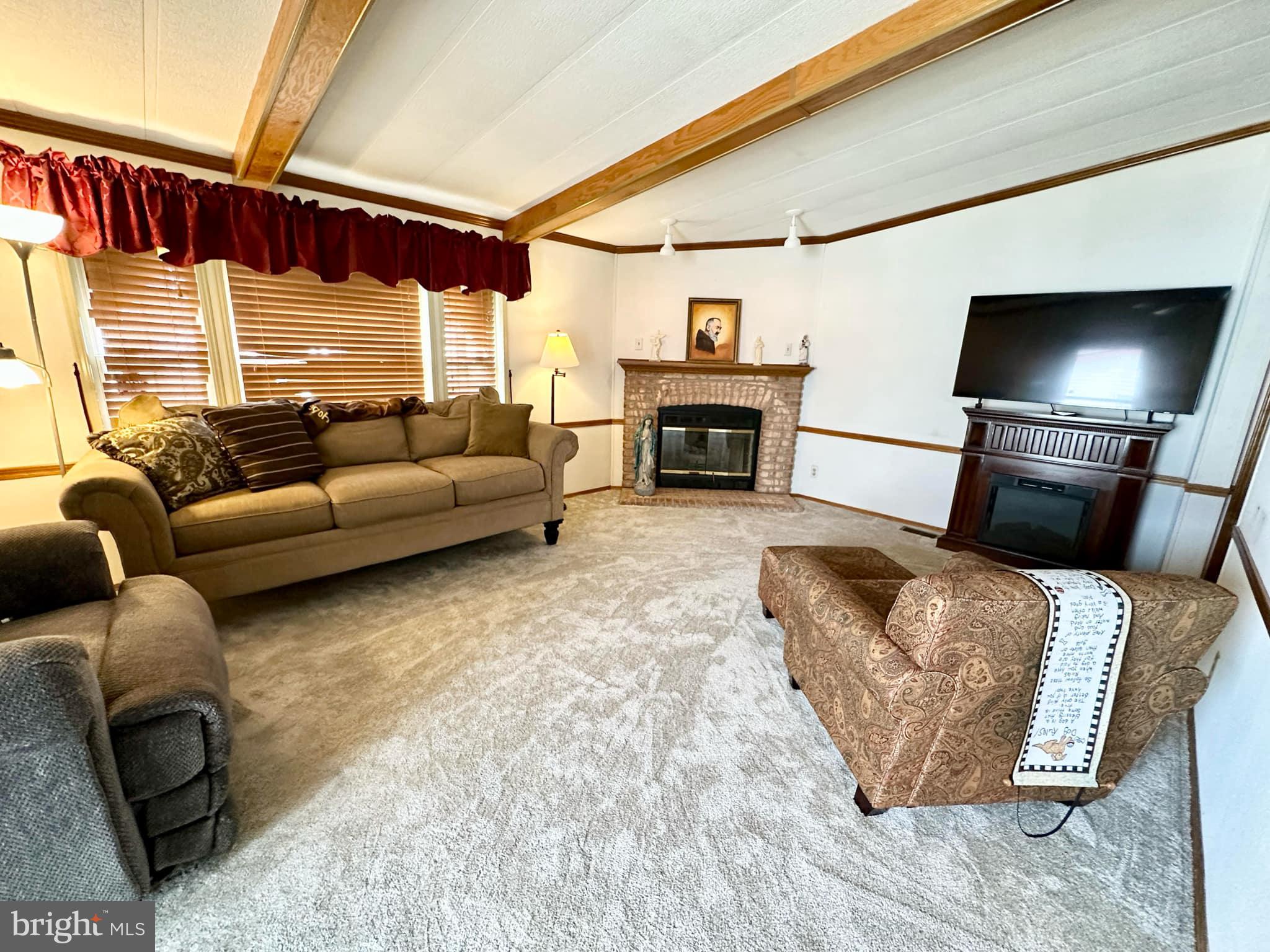 314 John Alden Drive Buena, NJ 08310 - Photo 10 of 23 a living room with furniture a fireplace and a flat screen tv