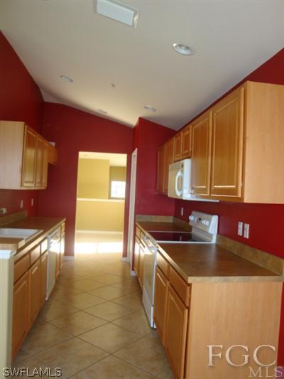 2623 Somerville Loop, Unit 508 Cape Coral, FL 33991 - Photo 7 of 10 a kitchen with stainless steel appliances granite countertop a sink and a stove